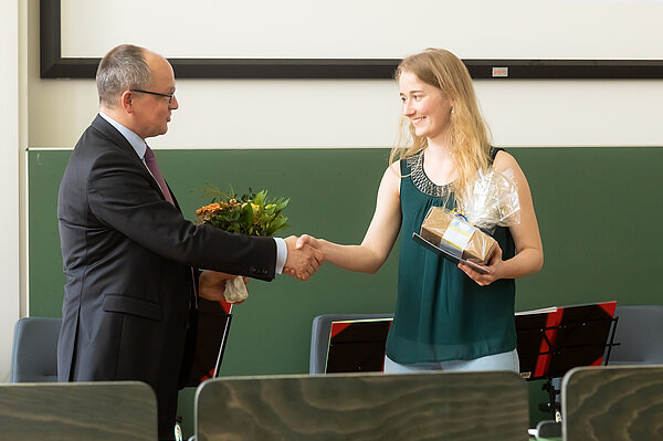 HTWK-Rektor Prof. Mark Mietzner beglückwünscht Preisträgerin Sophie Schulze. (Foto: Swen Reichhold/HTWK Leipzig) Mann gratuliert Frau in Hörsaal